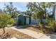 Spacious backyard features a large storage shed, green trees, and a wooden fence at 418 N Barrow Ave, Tavares, FL 32778