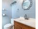 Bathroom featuring a classic vanity, toilet, and decorative mirror at 418 N Barrow Ave, Tavares, FL 32778