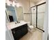 Bathroom featuring modern vanity with white countertop and black fixtures, tiled floors and a glass shower at 4425 Lions Gate Ave, Clermont, FL 34711