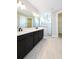 Modern bathroom with dual sinks, a large mirror, and a glass-enclosed shower at 4425 Lions Gate Ave, Clermont, FL 34711