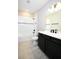Bright bathroom featuring shower-tub combo, single sink and dark cabinets at 4425 Lions Gate Ave, Clermont, FL 34711