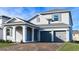 Two-story home features a gray exterior, arched entryway, brick driveway, and a two-car garage at 4425 Lions Gate Ave, Clermont, FL 34711