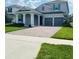 Charming two-story home featuring a brick driveway, attached two-car garage, and well-maintained front lawn at 4425 Lions Gate Ave, Clermont, FL 34711