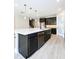 Open kitchen with marble island, dark cabinets, stainless appliances, and stylish pendant lighting at 4425 Lions Gate Ave, Clermont, FL 34711