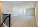 Open living room area with hardwood floors, neutral color palette, staircase, and natural light at 4425 Lions Gate Ave, Clermont, FL 34711