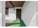 Inviting front entrance with a dark wooden door, decorative rocks, a green mat, and white exterior walls at 549 Constitution Dr, Orlando, FL 32809