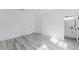 Well-lit bedroom with white walls, vinyl flooring and an open doorway to a bathroom at 6732 Sw 132Nd St, Ocala, FL 34473