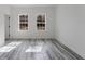 Well-lit bedroom with two large windows, wood-look floors, and white walls at 6732 Sw 132Nd St, Ocala, FL 34473