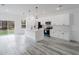 Modern kitchen featuring white cabinetry, island, stainless steel appliances, and hardwood floors at 6732 Sw 132Nd St, Ocala, FL 34473