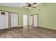 Large bedroom with two closets, wood-look floors and ceiling fan at 6749 Crescent Ridge Rd, Orlando, FL 32810