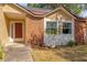 Brick and tan exterior with a red door and landscaping at 6749 Crescent Ridge Rd, Orlando, FL 32810