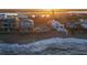 A scenic aerial view showcases beachfront homes with inviting decks overlooking the ocean and bay during sunrise at 6877 S Atlantic Ave, New Smyrna Beach, FL 32169