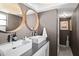 Modern bathroom with dual sinks, round mirrors, and sleek fixtures at 6877 S Atlantic Ave, New Smyrna Beach, FL 32169
