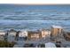 An aerial view of beachfront homes, offering a prime coastal living experience with ocean views and private beach access at 6877 S Atlantic Ave, New Smyrna Beach, FL 32169