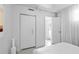 Bright bedroom featuring white walls, tiled floor, closet, and an open door, creating a clean and inviting space at 6877 S Atlantic Ave, New Smyrna Beach, FL 32169