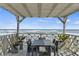 Outdoor dining area with ocean view under a pergola, complemented by stylish decor, creating an inviting entertainment space at 6877 S Atlantic Ave, New Smyrna Beach, FL 32169