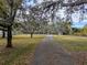 Long driveway leading to a two-story home with lush landscaping at 9430 Kilgore Rd, Orlando, FL 32836