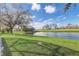 Scenic backyard featuring a large pond view from a well-maintained lawn at 9716 Pecky Cypress Way, Orlando, FL 32836