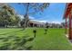 A beautiful backyard with built-in grills near a covered picnic area, with green grass and a home view at 9716 Pecky Cypress Way, Orlando, FL 32836