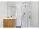 Bright bathroom featuring a glass shower, wood vanity and a large, marble-tiled wall at 9716 Pecky Cypress Way, Orlando, FL 32836