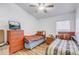 Cozy bedroom featuring wood laminate flooring, twin beds, and a chest of drawers at 9716 Pecky Cypress Way, Orlando, FL 32836