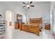 Bright main bedroom with a vaulted ceiling, tile floors, and a wooden bed frame at 9716 Pecky Cypress Way, Orlando, FL 32836