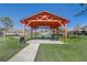 Inviting picnic area with a wooden gazebo, tables, and lush green space, perfect for outdoor gatherings at 9716 Pecky Cypress Way, Orlando, FL 32836