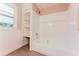 Well-lit bathroom featuring a shower-tub combo with storage shelves and neutral decor at 1032 W 2Nd St, Sanford, FL 32771