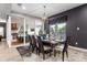 Modern dining room features a sleek table, chandelier, and access to the outdoor kitchen at 1039 Jack Nicklaus Ct, Kissimmee, FL 34747