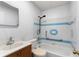 Bathroom featuring tiled shower and bathtub, sink with vanity, toilet, grab bar and blue and white accents at 105 N Ortman Dr, Orlando, FL 32805