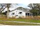 White single story house with a screened porch and overgrown yard at 105 N Ortman Dr, Orlando, FL 32805