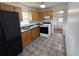 Functional kitchen features wood cabinets, essential appliances, and durable tiled flooring for easy maintenance at 105 N Ortman Dr, Orlando, FL 32805