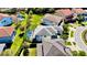 Aerial view of a house with pool in the back yard. The house has a gray roof and is surrounded by a green lawn at 10680 Royal Cypress Way, Orlando, FL 32836