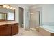 Modern bathroom with a large walk-in shower, soaking tub and double vanity at 10680 Royal Cypress Way, Orlando, FL 32836