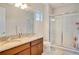 Bathroom with granite countertop, double vanity, and a walk-in shower at 10680 Royal Cypress Way, Orlando, FL 32836