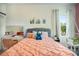 Bedroom with a coral comforter, gray upholstered headboard and a white brick feature wall at 10680 Royal Cypress Way, Orlando, FL 32836
