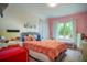 Bright bedroom with coral bedding, gray headboard, and a window seat at 10680 Royal Cypress Way, Orlando, FL 32836
