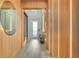 Modern entryway with a large circular mirror and wood paneling at 10680 Royal Cypress Way, Orlando, FL 32836