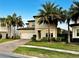 Two-story house with white garage door, landscaping, and palm trees at 10680 Royal Cypress Way, Orlando, FL 32836