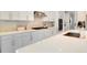 White kitchen with gas cooktop and expansive quartz countertops at 10680 Royal Cypress Way, Orlando, FL 32836