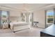Main bedroom with king-size bed, chandelier, and ample natural light at 10680 Royal Cypress Way, Orlando, FL 32836