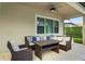 Covered patio with wicker furniture and a coffee table at 10680 Royal Cypress Way, Orlando, FL 32836