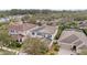 Aerial view of a two-story house with a red mulch driveway, surrounded by trees and other houses at 11412 Chateaubriand Ave, Orlando, FL 32836