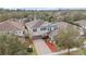 Aerial view of a two-story house with a red mulch driveway, surrounded by trees and other houses at 11412 Chateaubriand Ave, Orlando, FL 32836