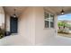Covered porch with a blue door and light fixtures at 11412 Chateaubriand Ave, Orlando, FL 32836