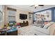 Gathering room with sectional sofa, built-in shelving, and large TV at 11412 Chateaubriand Ave, Orlando, FL 32836