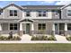 Charming townhome featuring a welcoming front porch with stone accents and beautifully manicured landscaping at 1273 Coral Bean Ln, Winter Springs, FL 32708