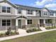Inviting townhome with a delightful front porch, showcasing stone pillars and lush greenery at 1273 Coral Bean Ln, Winter Springs, FL 32708