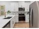 Modern kitchen boasts white cabinets, stainless steel appliances, light countertops and hardwood style floors at 1273 Coral Bean Ln, Winter Springs, FL 32708