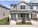 Charming two-story townhome featuring a covered front porch with stone accents and manicured landscaping at 1309 Coral Bean Ln, Winter Springs, FL 32708